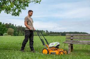 AS-Motor AS 510 E-ProClip A AP in action mowing grass, young man walking behind the mower