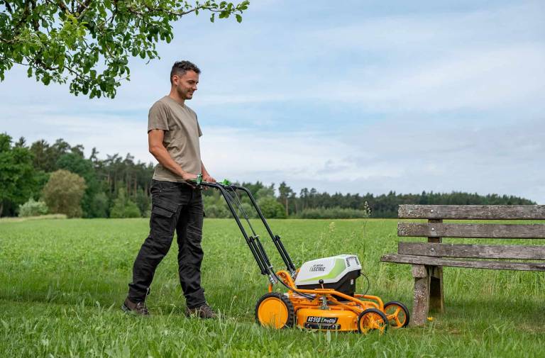 AS-Motor AS 510 E-ProClip A AP in action mowing grass, young man walking behind the mower