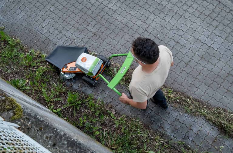 AS 30 E-WeedHex AP in action, brushing/removing weed on cobblestone