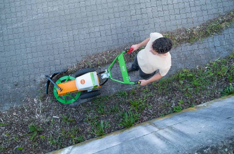 AS 60 E-WeedHex AP in action, brushing/removing weed on cobblestone